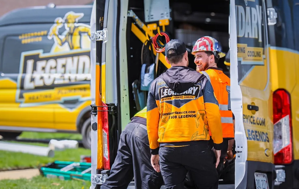 Legendary Service technicians standing beside a branded service van