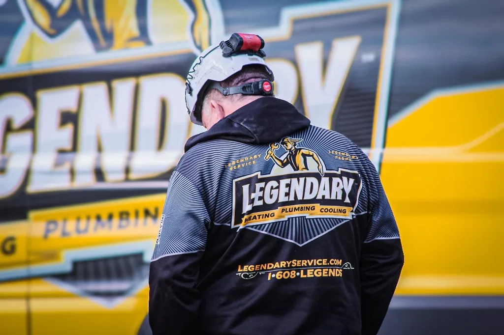 Legendary Service technician wearing a branded jacket at a job site
