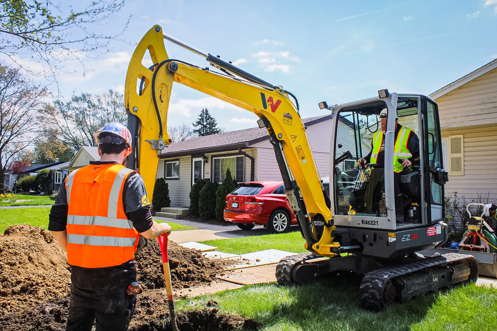 Legendary Service crew operating a mini excavator for underground plumbing work