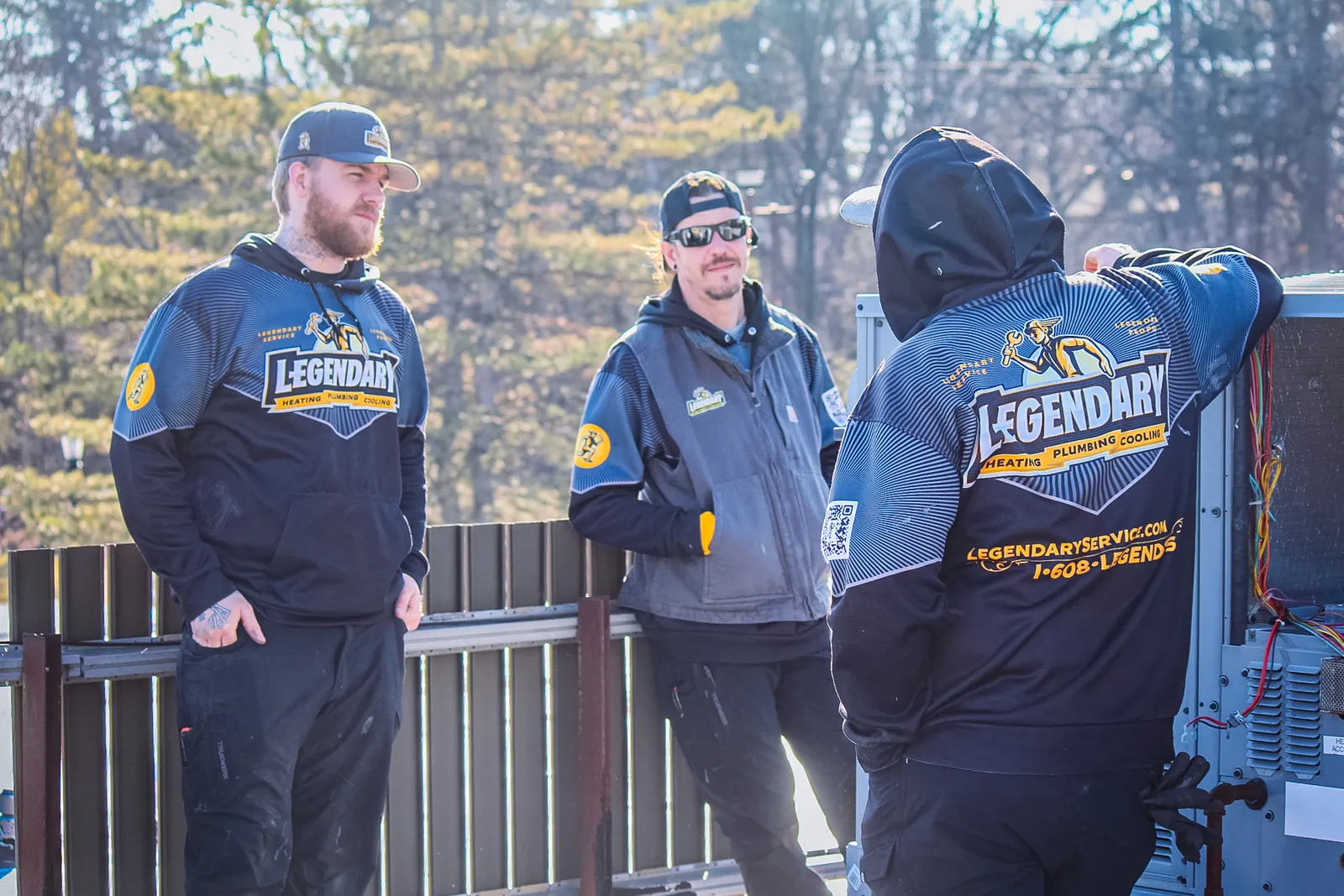 Legendary Service technicians in branded black and gold uniforms on a job site