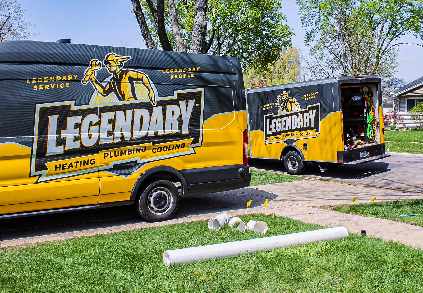 Legendary Service marked vans staged on a residential street during a job