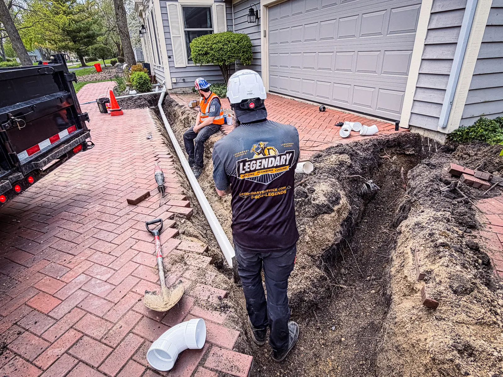 Legendary Service technicians repairing a drain line in an open trench